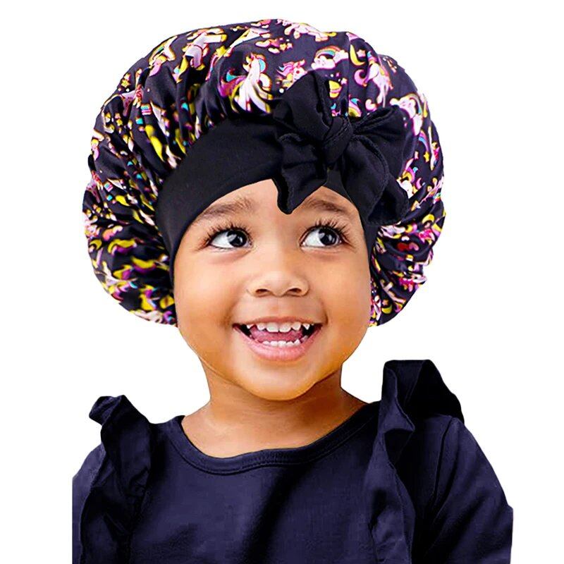 New Kids Unicorn Satin Bonnet with Wide Elastic Band and Ribbon, Perfect for Curly and Natural Hair, Perfect as a Nightcap, Shower Cap, or Headscarf. One Size; Imported.