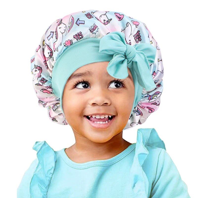New Kids Unicorn Satin Bonnet with Wide Elastic Band and Ribbon, Perfect for Curly and Natural Hair, Perfect as a Nightcap, Shower Cap, or Headscarf. One Size; Imported.