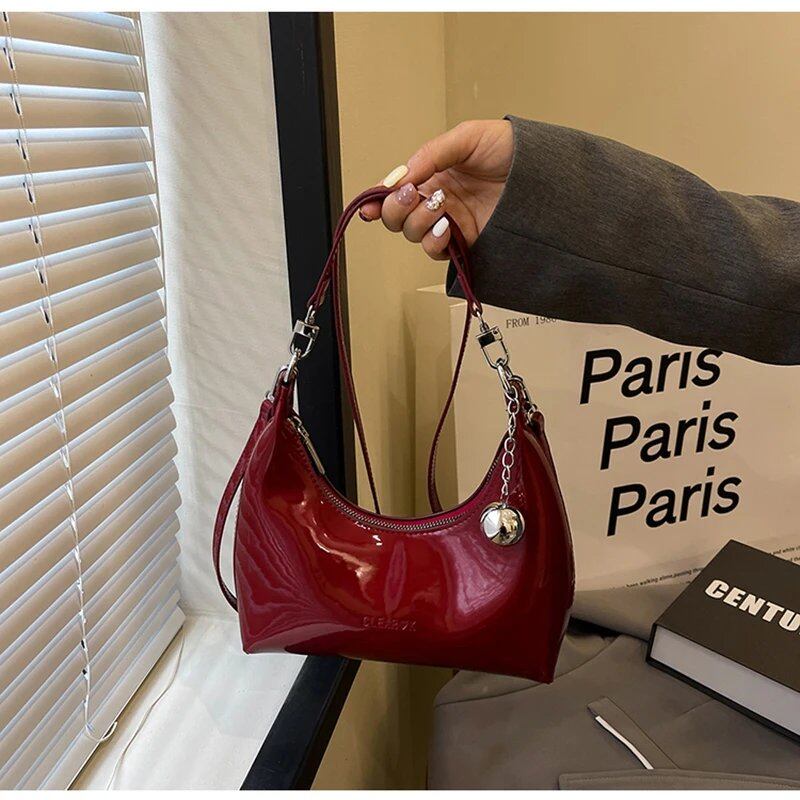 This elegant cherry red lacquer crossbody bag features a pendant and zipper closure. Perfect for commuting, this under-arm bag is new and perfect for women. Size: 20cm (maximum length &lt; 30cm); Parallel import.